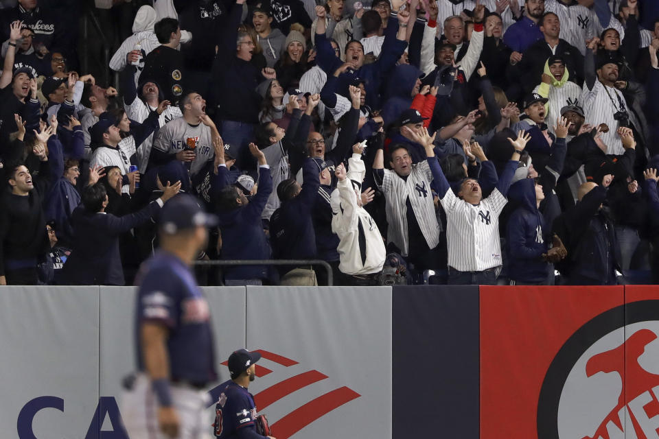 Baseball fans react after a solo home run by New York Yankees' Brett Gardner against the Minnesota Twins during the sixth inning of Game 1 of an American League Division Series baseball game, Friday, Oct. 4, 2019, in New York. (AP Photo/Frank Franklin II)