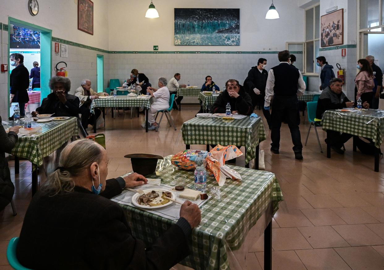 Persons in need eat lunch served at the canteen of lay Catholic Community of Sant'Egidio dedicated to social service in Rome, Italy on April 13, 2020, during the country's lockdown aimed at curbing the spread of the COVID-19 infection, caused by the novel coronavirus.