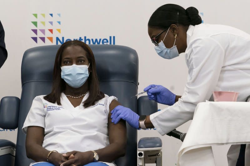 Sandra Lindsay, (L) a nurse at Long Island Jewish Medical Center, is inoculated with the COVID-19 vaccine by Dr. Michelle Chester on December 14, 2020, in the Queens borough of New York. File Photo by Mark Lennihan/UPI