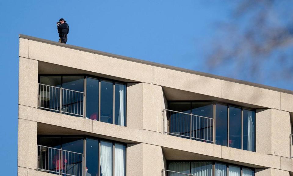 A law enforcement officer scans the crowd with binoculars after a shooting broke out following the Kansas City Chiefs Super Bowl LVIII victory parade on Wednesday, Feb. 14, 2024, in Kansas City.