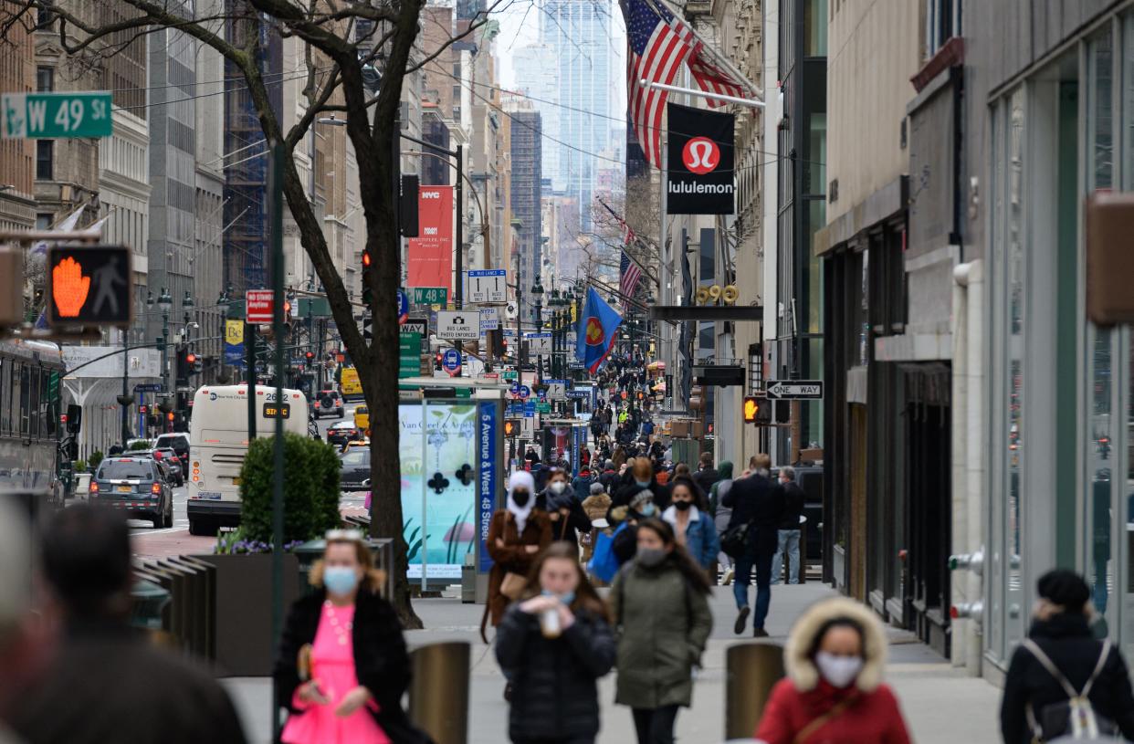 People walk on a busy 5th Avenue in midtown Manhattan on April 2, 2021 in New York City.