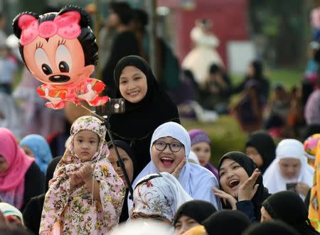 A group of women pose for a picture, before the start of Eid Al-Fitr prayers, which marks the end of the holy fasting month of Ramadan at Luneta Park in Metro Manila, Philippines June 25, 2017. REUTERS/Dondi Tawatao