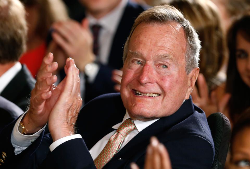 Former President George H. W. Bush applauds during an event to honor the winner of the 5,000th Daily Point of Light Award at the White House in Washington in this file photo from July 15, 2013. Bush was taken by ambulance to the Houston Methodist Hospital as a precaution after experiencing a shortness of breath December 23, 2014, according to a statement from his office. REUTERS/Kevin Lamarque/Files (UNITED STATES - Tags: POLITICS)