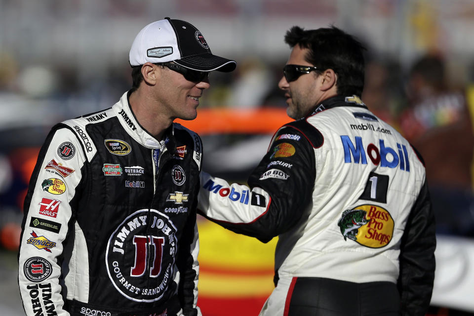 Kevin Harvick, left, talks with Tony Stewart during qualifying for Sunday's NASCAR Sprint Cup Series auto race on Friday, March 7, 2014, in Las Vegas. (AP Photo/Isaac Brekken)