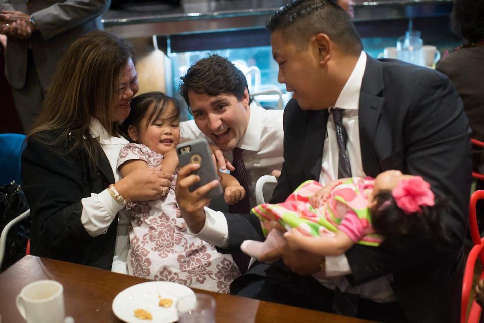 Prime Minister Justin Trudeau poses for a photograph with a family during a visit to a Filipino restaurant in Surrey, B.C, on May 19, 2017. A Statistics Canada study found Filipinos have higher rates of employment than people who are Canadian-born.