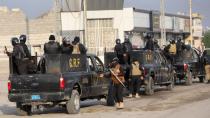 Iraqi security forces are seen on military vehicles during ongoing anti-government protests in Basra