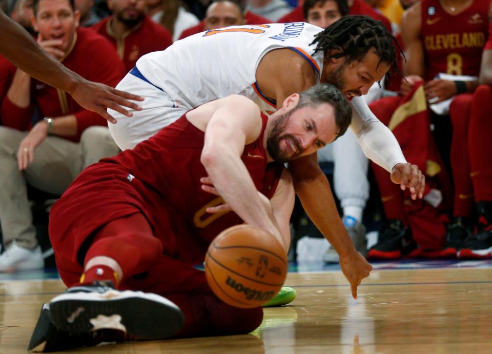New York Knicks guard Jalen Brunson, top, and Cleveland Cavaliers forward Kevin Love fight for the ball during the second half of an NBA basketball game, Sunday, Dec. 4, 2022, in New York. The Knicks won 92-81. (AP Photo/John Munson)