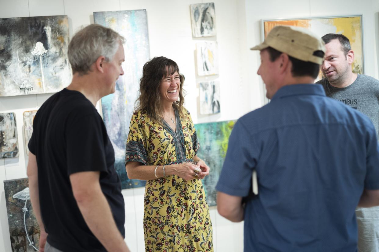 Kelly Reichert, artist and owner of 3060 Gallery, chats with other business tenents who work nearby during the Hilltop 3060 Art Brunch Saturday.