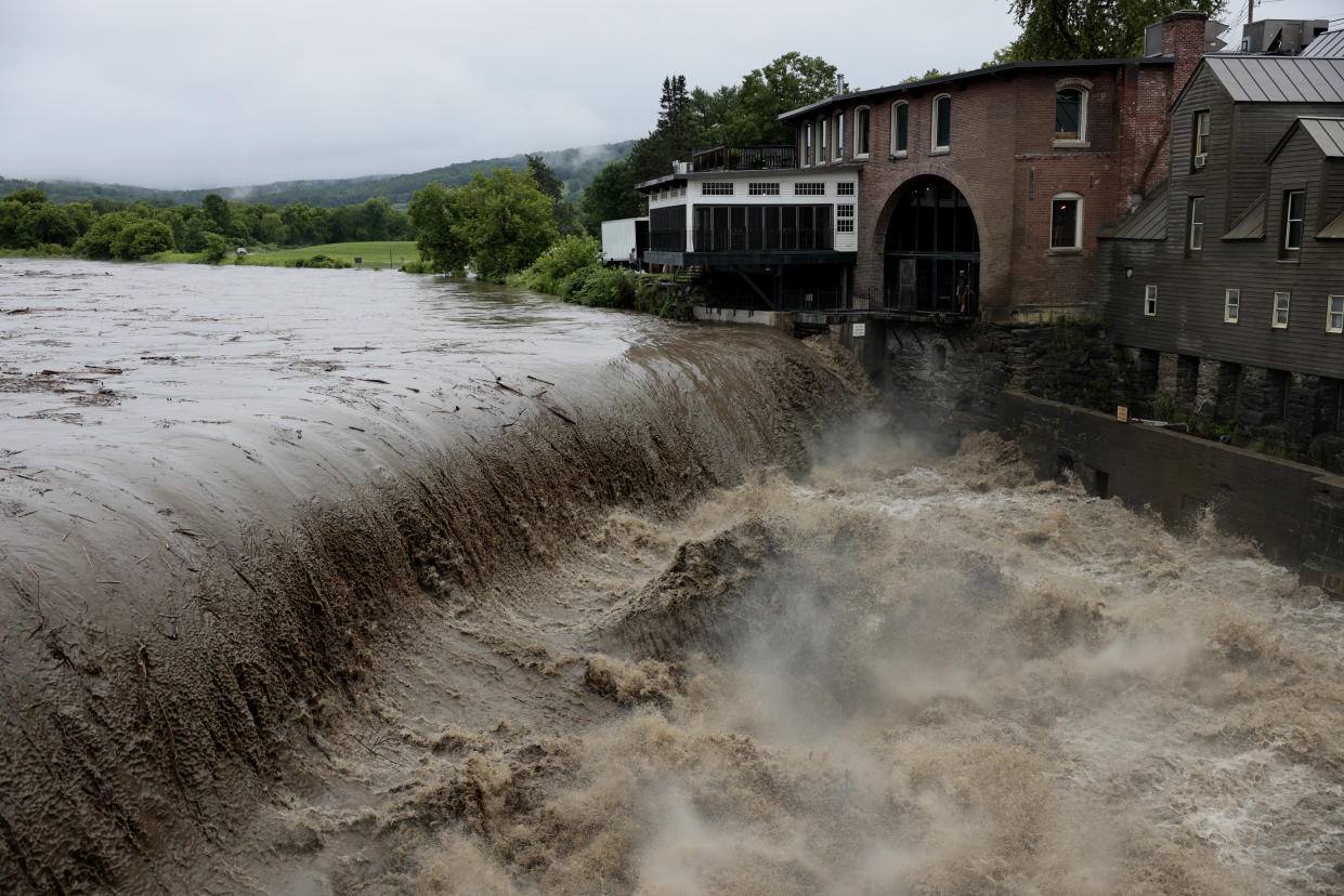 Heavy rain sends mud and debris down the Ottauquechee River in Queechee, Vermont.