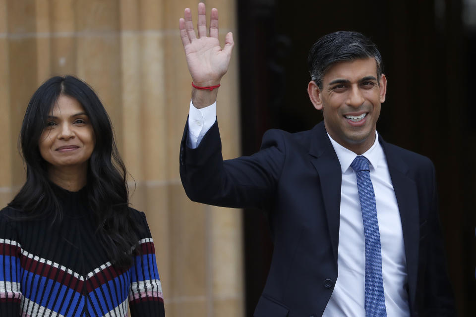Britain's Prime Minister Rishi Sunak with his wife Akshata Murthy wave as they arrive at the Queen's University Belfast in Belfast, Wednesday, April 19, 2023 during the international conference to mark the 25th anniversary of the Belfast/Good Friday Agreement. (AP Photo/Peter Morrison)