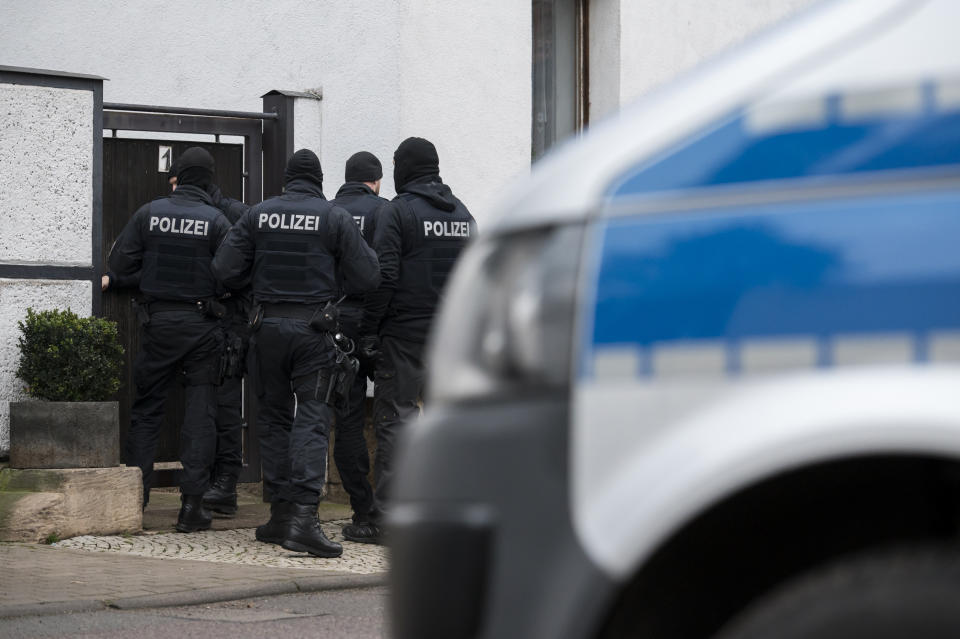 Police officers are standing in front of an apartment building in Erfurt, Germany, Thursday, Jan. 23, 2020. Germany's top security official has announced a ban on the neo-Nazi group 'Combat 18' Deutschland. A spokesman for Interior Minister Horst Seehofer said police were conducting raids early Thursday in six German states. (Jens-Ulrich Koch/dpa via AP)