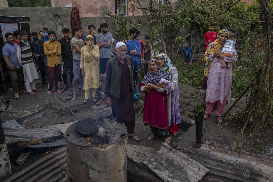 Kashmiri villagers cry near a damaged residential house where suspected rebels had taken refuge, after a gunfight in Pulwama, south of Srinagar, Indian controlled Kashmir, Wednesday, July 14, 2021. Three suspected rebels were killed in a gunfight in Indian-controlled Kashmir on Wednesday, officials said, as violence in the disputed region increased in recent weeks. Two residential houses were also destroyed. (AP Photo/ Dar Yasin)