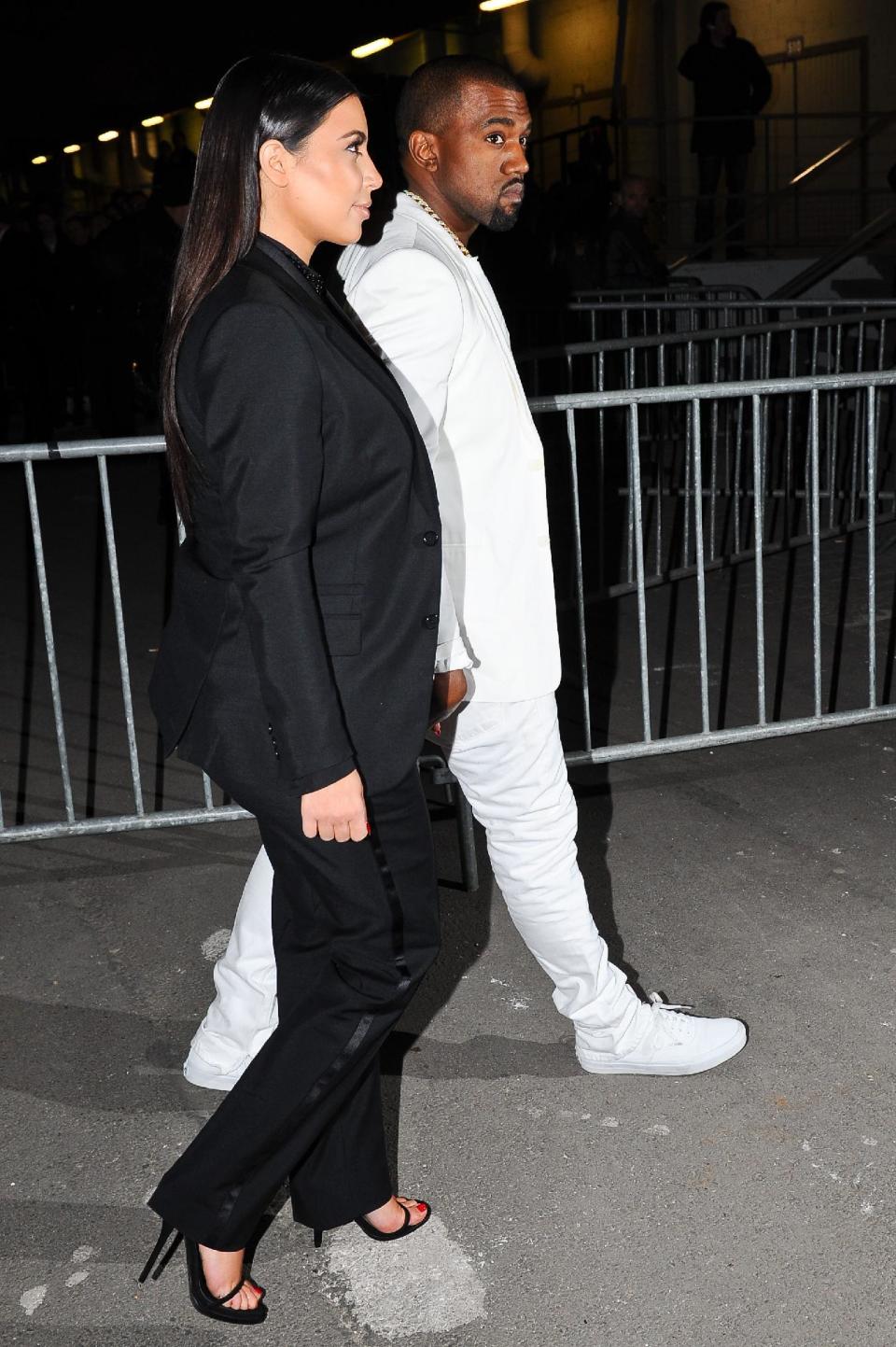 Kim Kardashian and Kanye West arrive at Givenchy's Ready to Wear's Fall-Winter 2013-2014 fashion collection presented Sunday, March 3, 2013 in Paris. (AP Photo/Zacharie Scheurer)