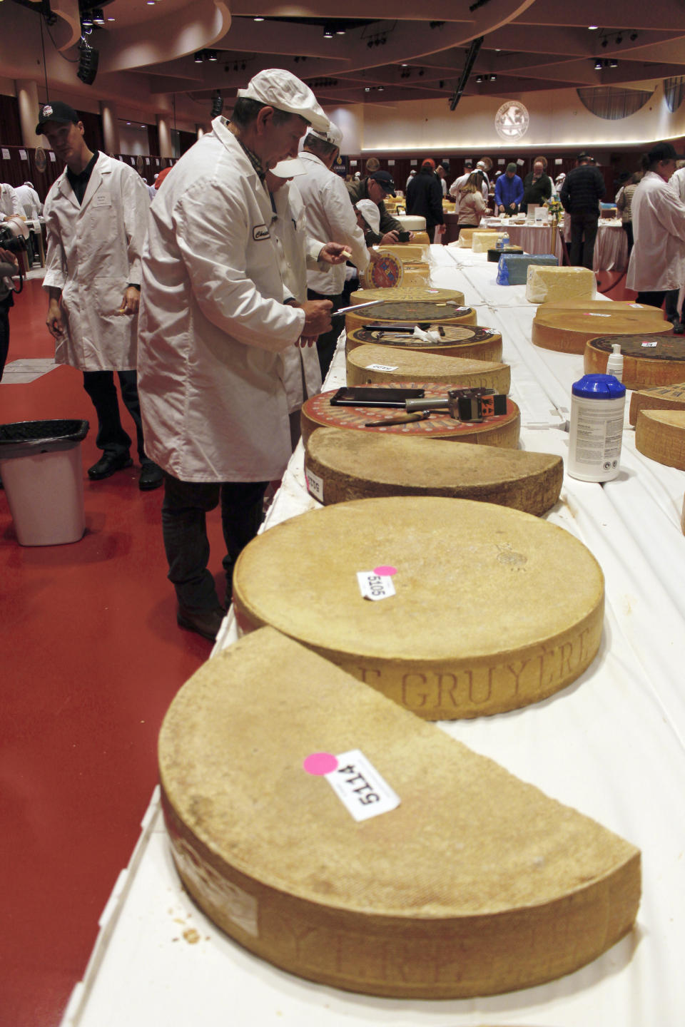 Judge Christophe Megevand inspects a wheel of Gruyere cheese at the biennial World Championship Cheese Contest, Tuesday, March 3, 2020, at the Monona Terrace Convention Center in Madison, Wis. It's the largest technical cheese, butter and yogurt competition in the world. This year the competition had a record 3,667 entries from 26 nations. (AP Photo/Carrie Antlfinger)