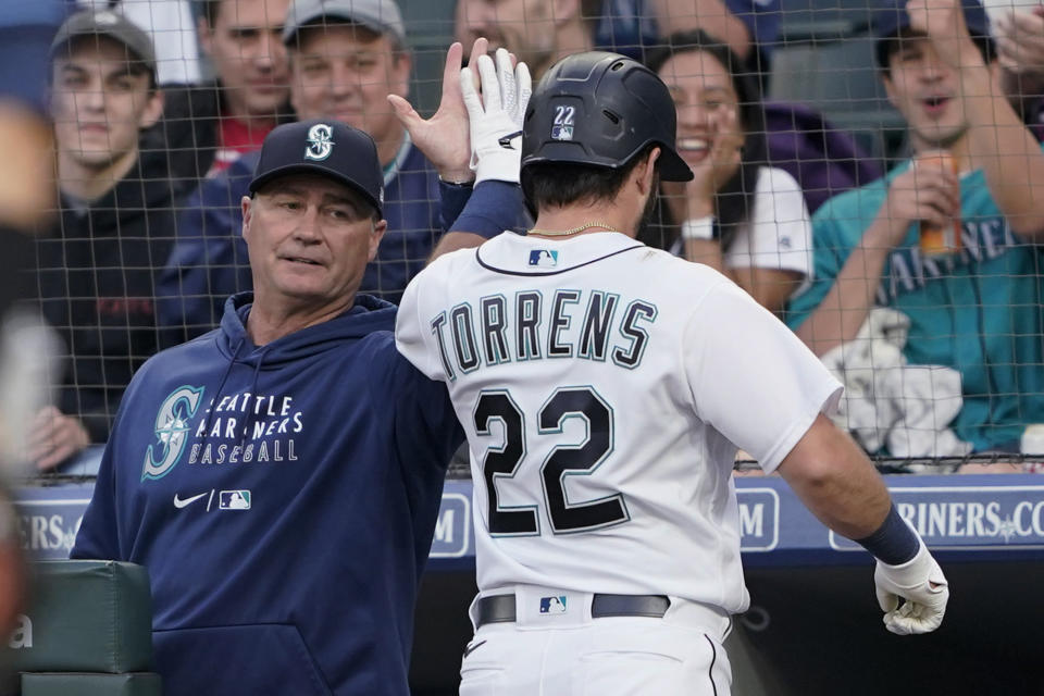 Seattle Mariners manager Scott Servais, left, greets Luis Torrens after Torrens hit a solo home run against the Tampa Bay Rays during the fifth inning of a baseball game Thursday, June 17, 2021, in Seattle. (AP Photo/Ted S. Warren)