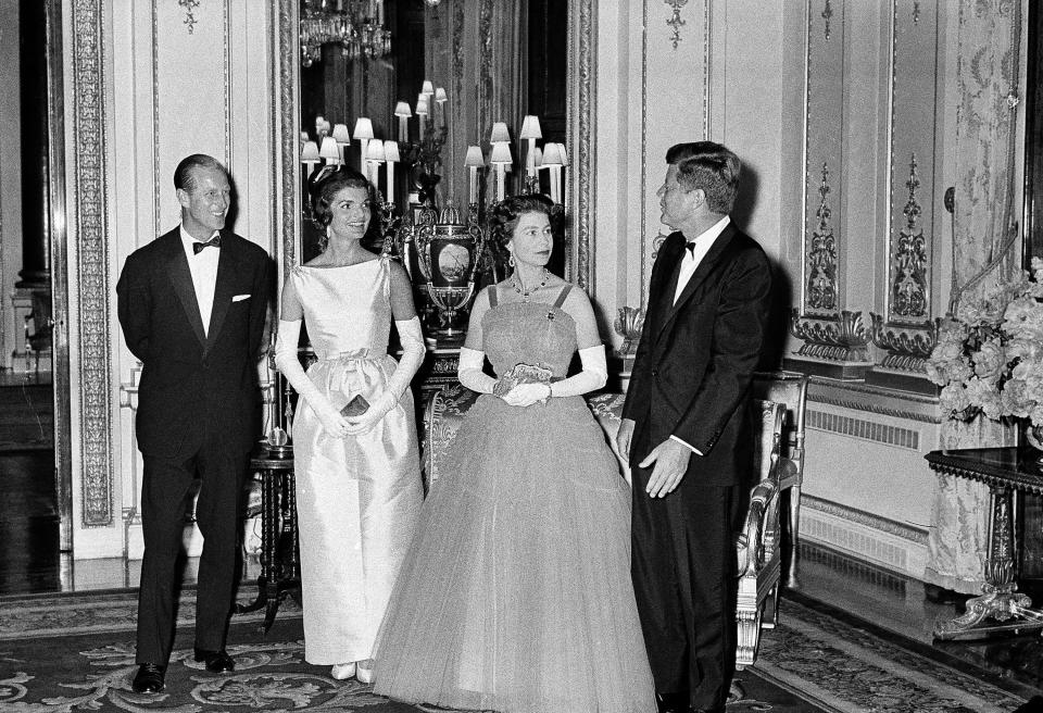 Prince Philip, Jacqueline Kennedy, and Queen Elizabeth II listen to President John Kennedy at Buckingham Palace in London, June 5, 1961. The Kennedys were the guests of the Queen and Prince at dinner.