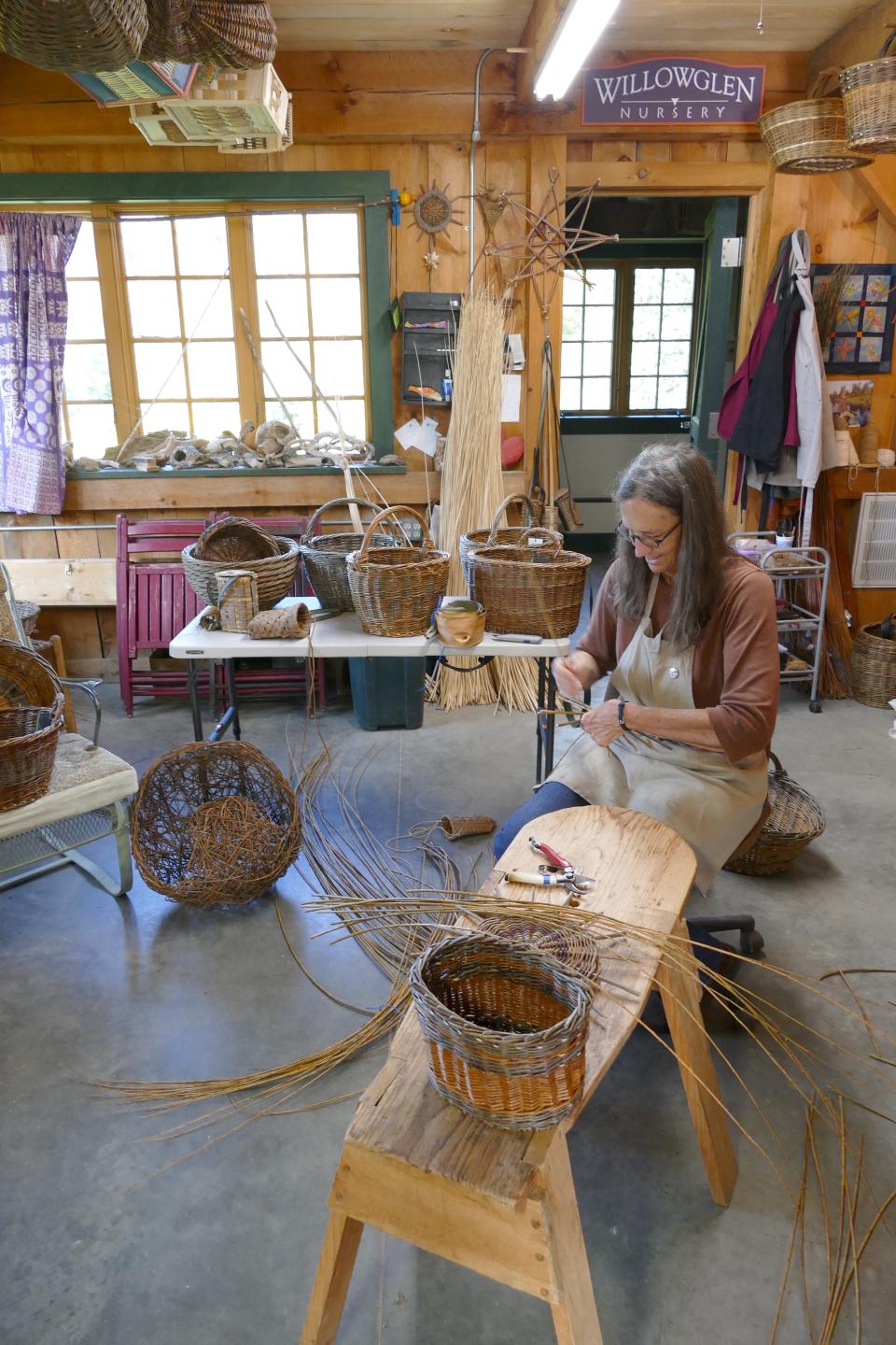 Lee Zieke begins work on a basket base using a simple twining method. “The thing that really got me about Willow is the texture and the patterns,” she says. The simple tools they use for cutting and weaving Willow are similar to those used by European basketmakers for generations. The handcrafted workbench is based on models Zieke saw in the Amanas.