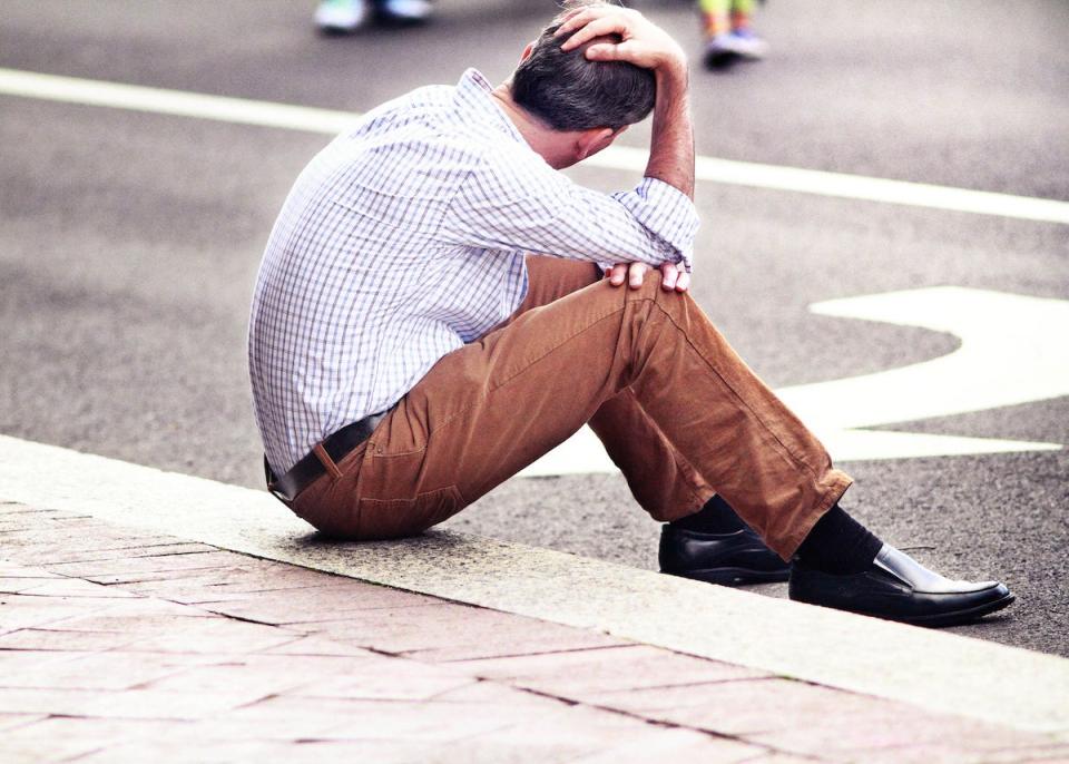 Man Stressed Sitting on Sidewalk