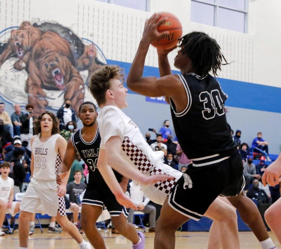 Bridgeport forward Colin Roberts (10) is knocked to the ground as YMLA’s Monterrio Golightly (30) shoots for two during a 4A Region 1 bi-district basketball game at Brewer High School in Fort Worth, Texas, Monday, Feb. 22, 2021. YMLA led by 12 at the half way mark. (Special to the Star-Telegram Bob Booth)