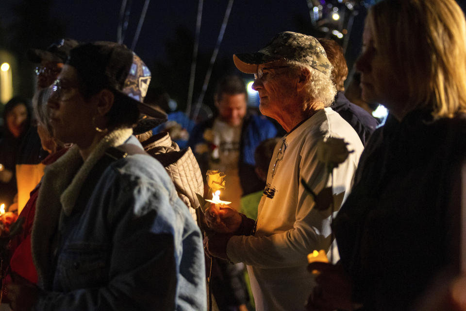 People gather at a memorial for high school student Jonathan Lewis Jr. near Rancho High School in eastern Las Vegas, on Tuesday, Nov. 21, 2023. Authorities have arrested at least eight students in connection with the beating of Lewis, who died a week after a prearranged fight broke out over a pair of headphones and a vape pen. (AP Photo/Ty O'Neil)