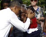 U.S. President Barack Obama shares a moment with Zoey Komongnan and her grandmother Mary at an event commemorating the 12th anniversary of the 9/11 attacks at the Pentagon near Washington, September 11, 2013. (REUTERS/Jason Reed)