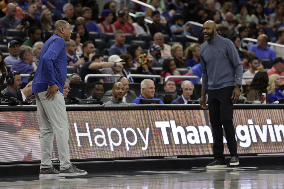 Philadelphia 76ers head coach Glenn "Doc" Rivers, left,talks with Orlando Magic head coach Jamahl Mosley, right, during the first half of an NBA basketball game, Friday, Nov. 25, 2022, in Orlando, Fla. (AP Photo/Kevin Kolczynski)