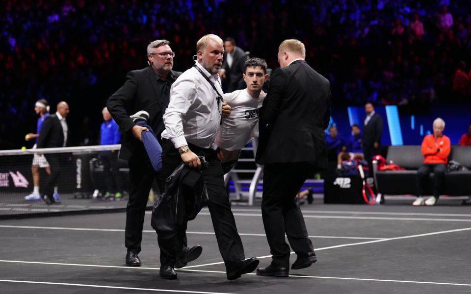 Stewards remove a protester after setting fire to the court on day one of the Laver Cup at the O2 Arena, London. Picture date: Friday September 23, 20 - PA