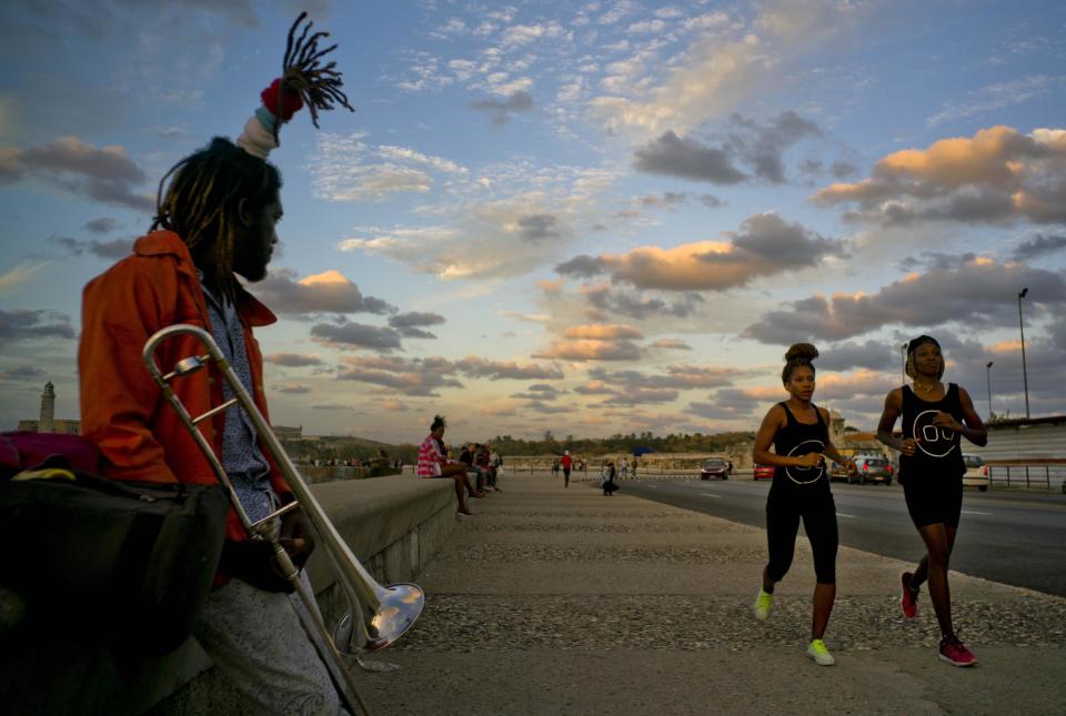 In this Jan. 30, 2017 photo, boxers Idamelys Moreno, second right, and Legnis Cala, right, run along Havana's Malecon, in Cuba. Moreno and Cala are part of a group of up-and-coming female boxers on the island who want government support to form Cuba's first female boxing team and help dispel a decades-old belief once summed up by a former top coach: "Cuban women are meant to show the beauty of their face, not receive punches." (AP Photo/Ramon Espinosa)