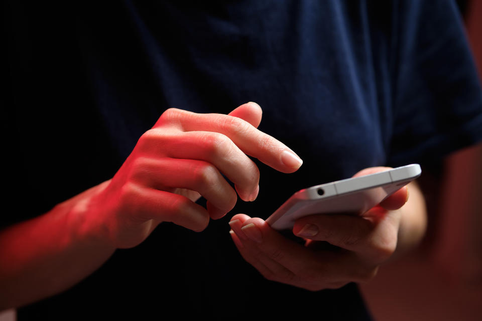 bank A mobile phone in the hands of a girl. A young woman in a black T-shirt is holding a phone. The fraudster sends an email message. The work of a freelancer, businessman. The wife checks messages and notifications on social networks. Wireless technologies.