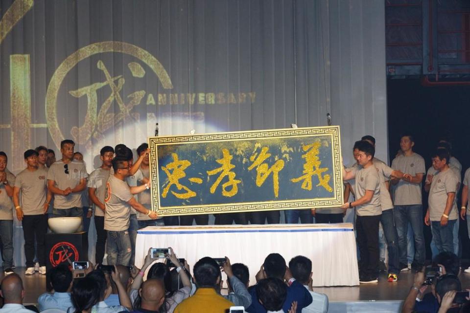 成家班在象徵其精神的匾額「忠孝節義」上灑下金粉。
