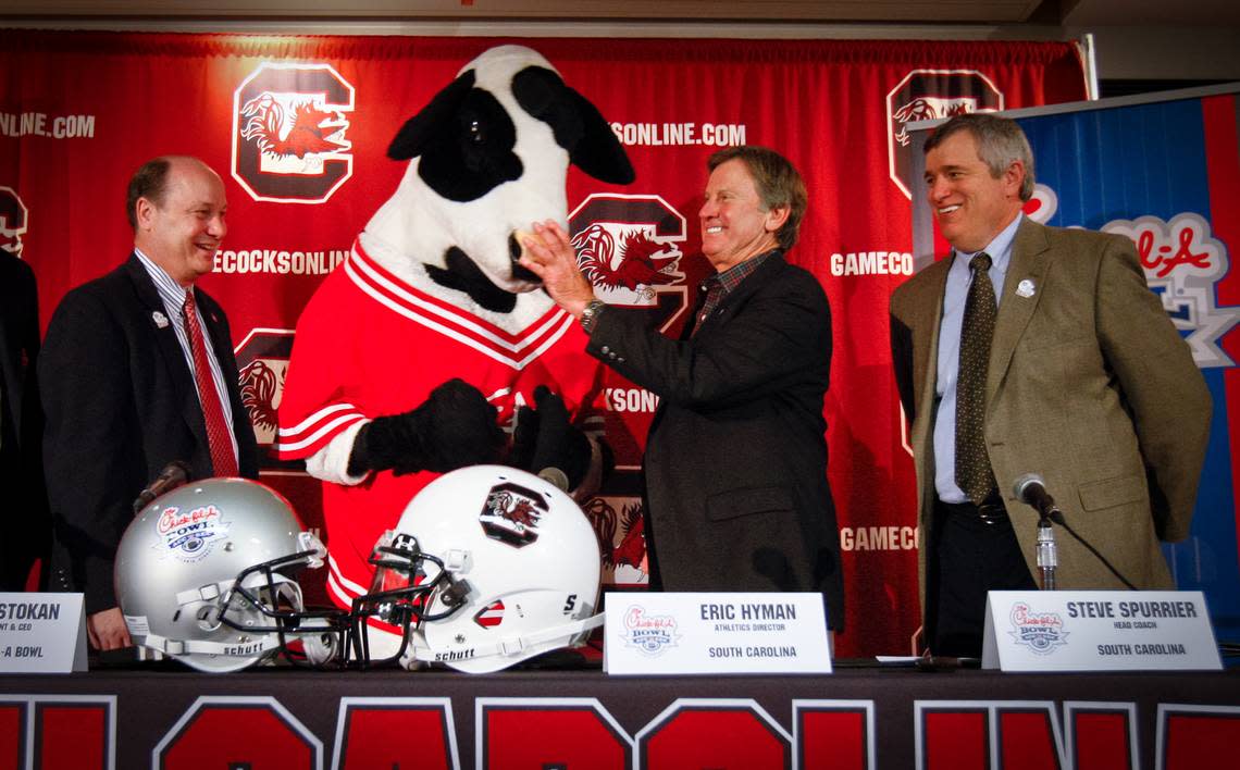 Left to right-Chick-fil-A Bowl President Gary Stokan, Coach Steve Spurrier, and USC A.D. Eric Hyman pose with the Chick-Fil-A cow mascot during a press conference about the upcoming bowl game between South Carolina and Florida State.