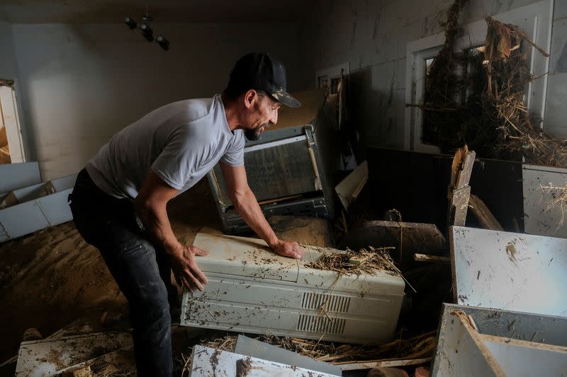 Abdul Salam Ibrahim Al-Qadi, 43 years old, looks inside his home for his father and brother who are missing after the deadly floods in Derna