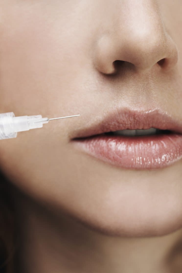 hypodermic needle next to a woman's lips