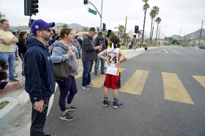 Spectators react to the scene of a helicopter crash that reportedly killed retired basketball star Kobe Bryant in Calabasas