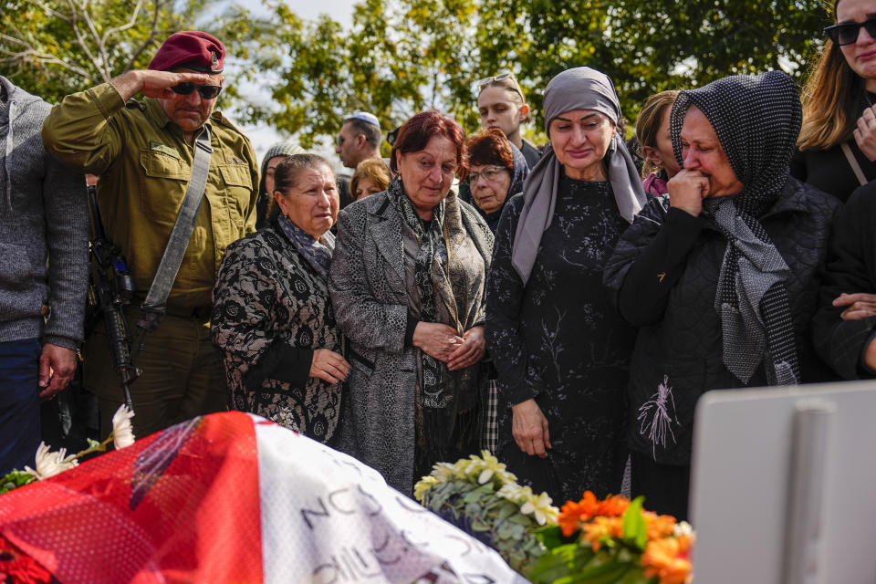Mourners gather in grief around the grave of Staff sergeant Simon Shlomov during his funeral in Rishon Lezion, Israel, Thursday, Feb. 22, 2024. Shlomov, 20, was killed during Israel's ground operation in the Gaza Strip, where the Israeli army has been battling Palestinian militants in the war ignited by Hamas' Oct. 7 attack into Israel. (AP Photo/Ariel Schalit)