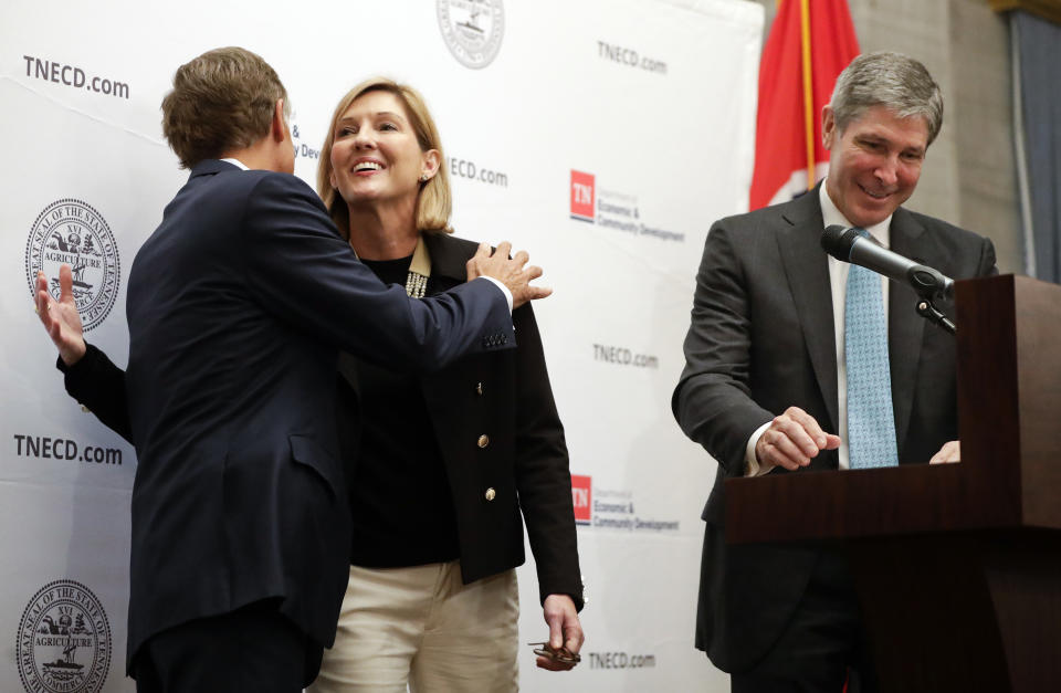 Holly Sullivan, center, of Amazon Public Policy, hugs Tennessee Gov. Bill Haslam during an announcement that Amazon will locate an operations hub in Nashville, Tenn., Tuesday, Nov. 13, 2018. At right is Economic and Community Development Commissioner Bob Rolfe. The $230 million-plus investment will make Nashville the eastern U.S. hub for Amazon's retail operations division. The investment will be the single largest jobs commitment made by a company in the state's history. (AP Photo/Mark Humphrey)