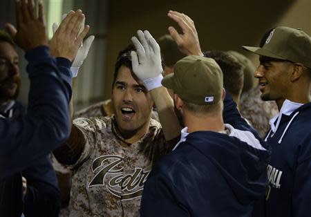 Mar 30, 2014; San Diego, CA, USA; San Diego Padres pinch hitter Seth Smith (12) celebrates with teammates in the dugout following a solo home run in the eighth inning on the opening day baseball game against the Los Angeles Dodgers at Petco Park. Christopher Hanewinckel-USA TODAY Sports