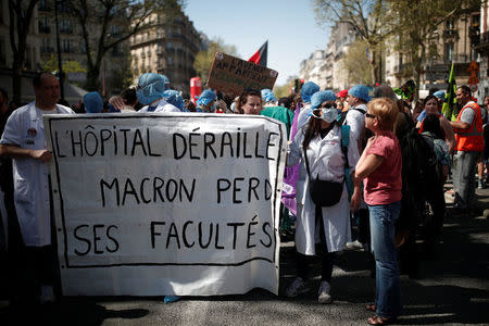 French health care workers hold a banner reading "The hospital derails, Macron loses his universities" during a demonstration against the French government's reform plans in Paris as part of a national day of protest, France, April 19, 2018. REUTERS/Benoit Tessier