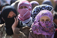 Lebanese and Syrian women cover their faces as they gather for a food aid food convoy at the main square of Tfail village, in the Lebanese-Syrian border, eastern Lebanon, Tuesday April 22, 2014. A Lebanese convoy of soldiers, clerics and Red Cross officials delivered aid Tuesday to a remote village near the Syrian border that was bombed by Syrian government aircraft and blocked by Lebanese militants fighting alongside President Bashar Assad’s forces in the civil war next door. Hezbollah fighters have been patrolling the area on the Lebanese side and fighting has flared up inside Syria, cutting Tfail’s residents off from all sides for months. (AP Photo/Hussein Malla)
