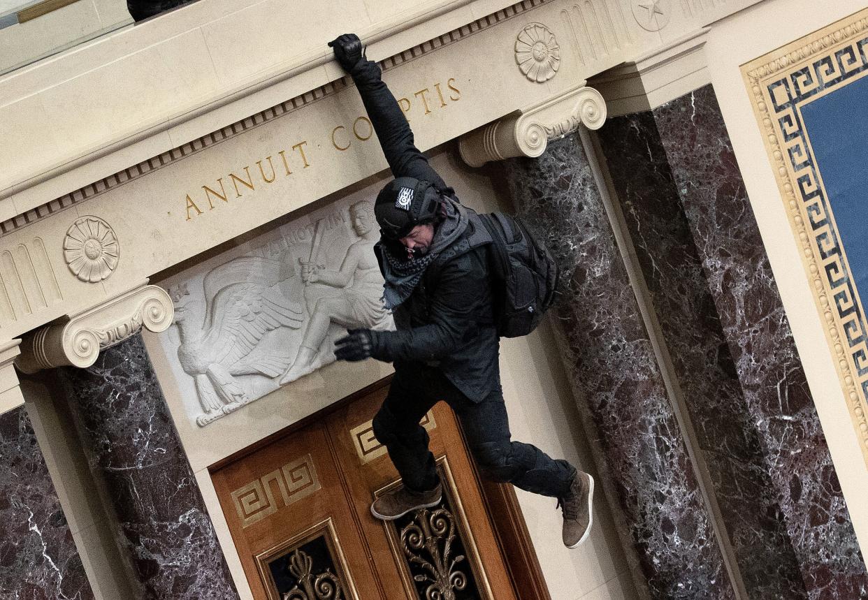 A protester supporting U.S. President Donald Trump jumps from the public gallery to the floor of the Senate chamber at the U.S. Capitol Building on January 06, 2021, in Washington, DC.