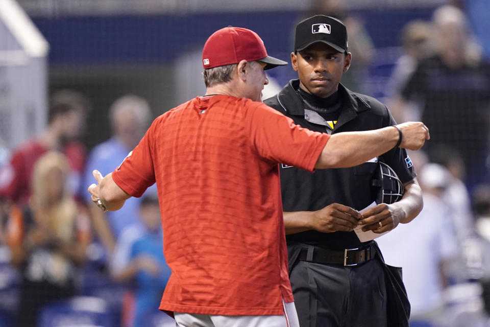 Cincinnati Reds manager David Bell, left, argues a call with home plate umpire Edwin Moscoso, right, during the ninth inning of a baseball game against the Miami Marlins, Sunday, Aug. 29, 2021, in Miami. (AP Photo/Lynne Sladky)