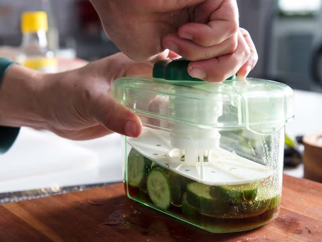 Quick cucumber pickles in a pickle press.