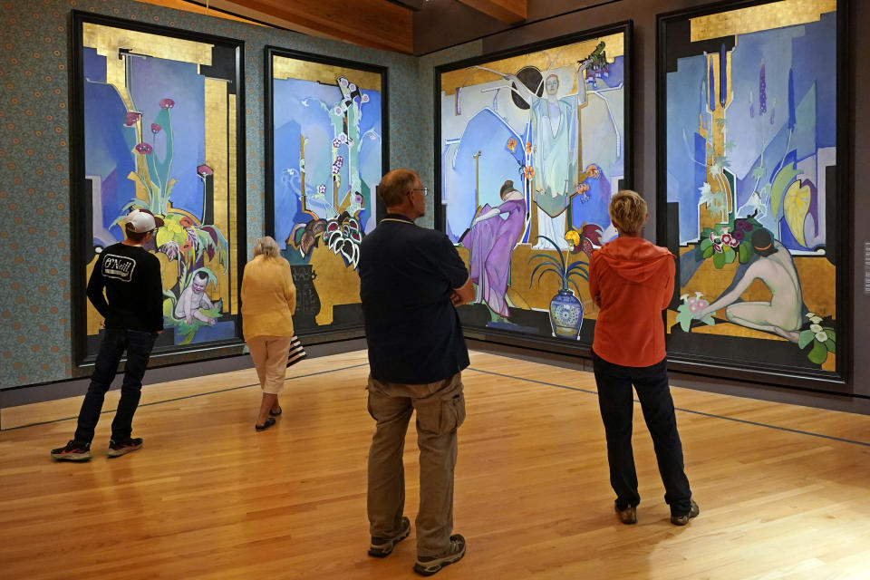 Visitors to the Crystal Bridges Museum of American Art view a group of mural panels titled "In Exaltation of Flowers" by Edward Steichen, Wednesday, April 19, 2023, in Bentonville, Ark. General admission to the museum is free. (AP Photo/Sue Ogrocki)