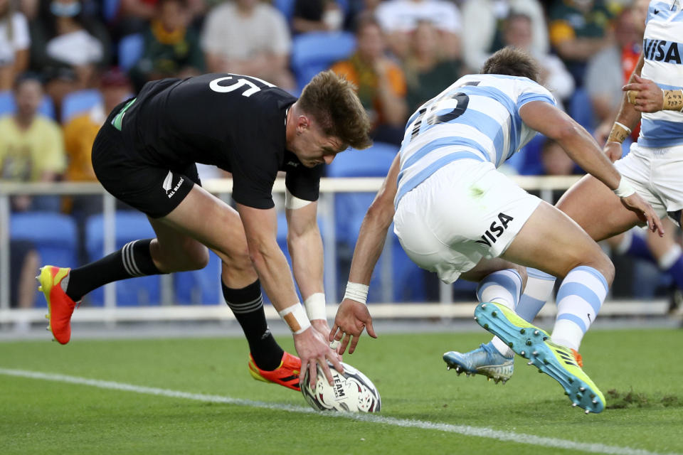 New Zealand's Jordie Barrett, left, touches down in a try attempt against Argentina's Juan Cruz Mallia during their Rugby Championship match on Sunday, Sept. 12, 2021, on the Gold Coast, Australia. (AP Photo/Tertius Pickard)