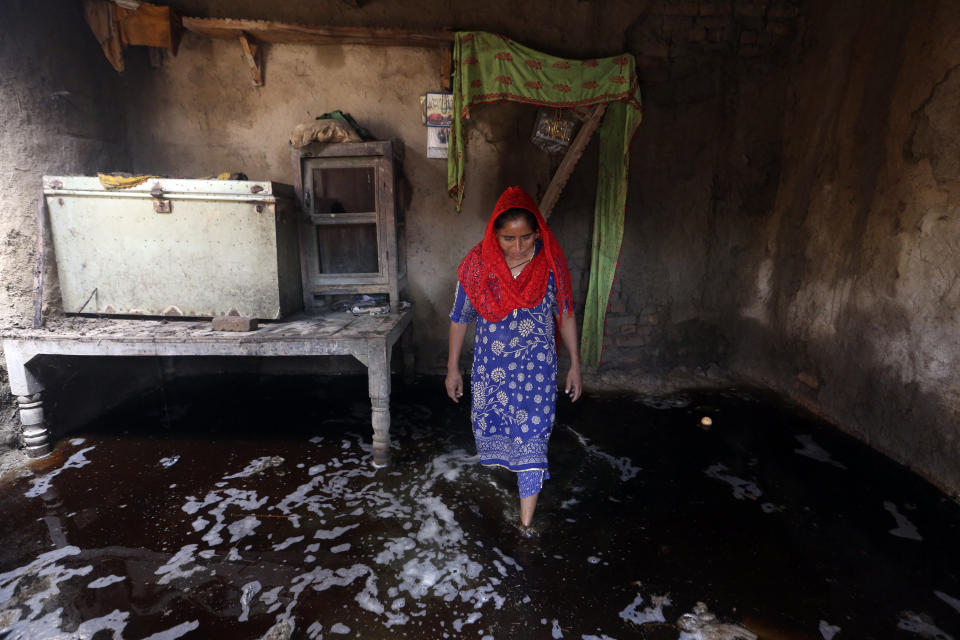 A woman looks for salvageable belongings from her flood-damaged home in the Shikarpur district of Sindh Province, Pakistan, Thursday, Sept. 1, 2022. Pakistani health officials on Thursday reported an outbreak of waterborne diseases in areas hit by recent record-breaking flooding, as authorities stepped up efforts to ensure the provision of clean drinking water to hundreds of thousands of people who lost their homes in the disaster. (AP Photo/Fareed Khan)