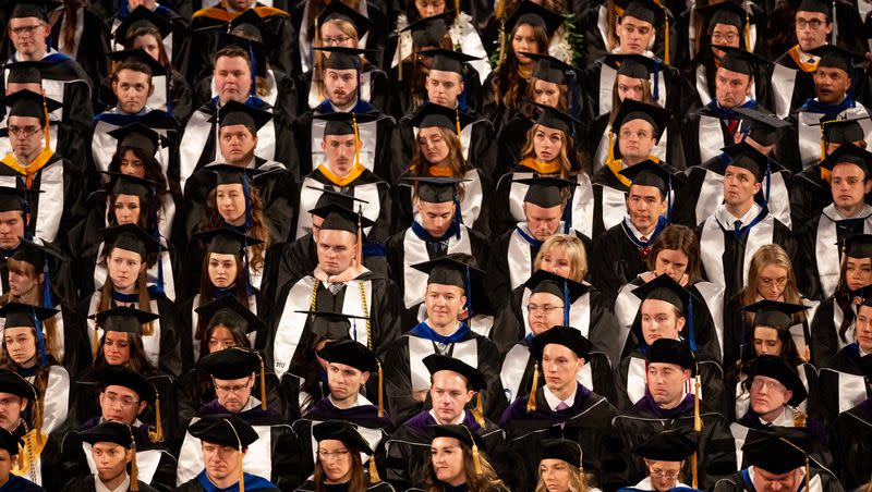 Soon-to-be graduates listen as Brigham Young University President Kevin J Worthen speaks at the university’s commencement at the Marriott Center in Provo on April 27, 2023.