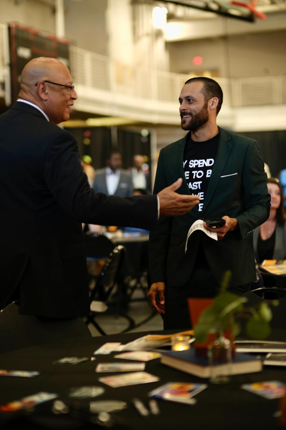 Shannon Ross, right, executive director of The Community, talks with Wisconsin Department of Corrections Secretary Kevin Carr. Beneath his blazer, the T-shirt reads, "Why spend more to bury the past when we can spend less to build the future."