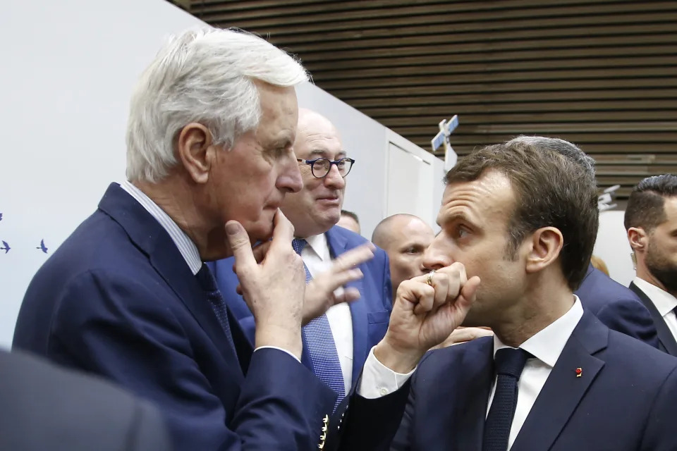 FILE - French President Emmanuel Macron, right, whispers to European Union chief Brexit negotiator Michel Barnier as he visits the International Agriculture Fair, in Paris, France. President Emmanuel Macron named the former EU Brexit negotiator as France's new prime minister on Thursday after more than 50 days of caretaker government. (AP Photo/Michel Euler, File)