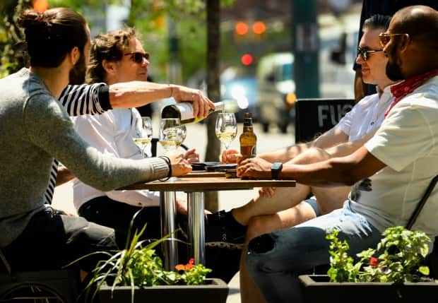 People enjoy drinks and friends on outdoor patios during the COVID-19 pandemic in downtown Toronto on Friday, June 11, 2021. (Nathan Denette/The Canadian Press - image credit)