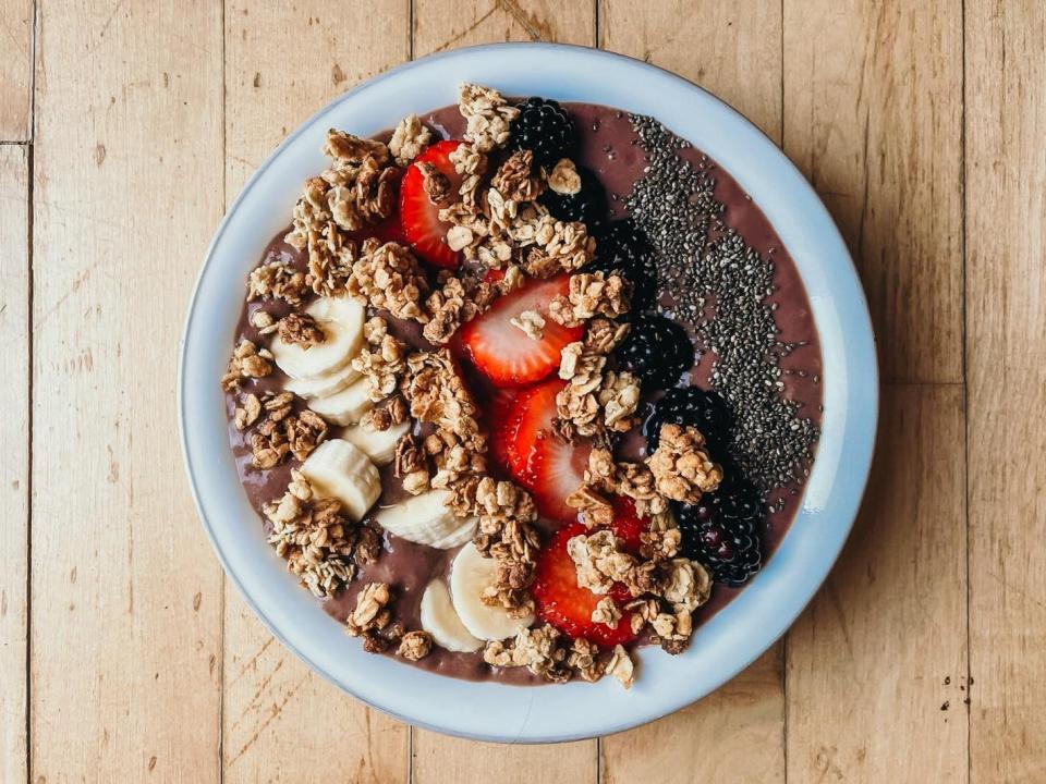 acai bowl with granola, bananas, strawberries, blackberries, and chia seeds